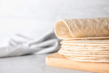 Wooden board with corn tortillas on table, space for text. Unleavened bread