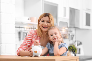 Obraz na płótnie Canvas Family with piggy bank and money at home