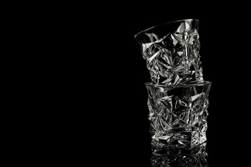 Empty whiskey glasses on black background. Space for text