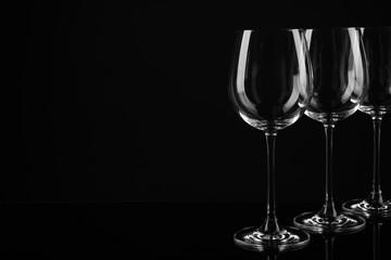 Set of empty wine glasses on black background. Space for text