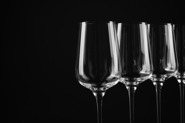 Set of empty wine glasses on black background. Space for text