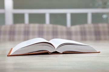 Open book on white table, education concept