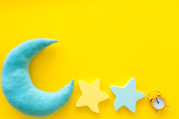 Sleep time concept with moon, stars, alarm clock on yellow background top view mockup