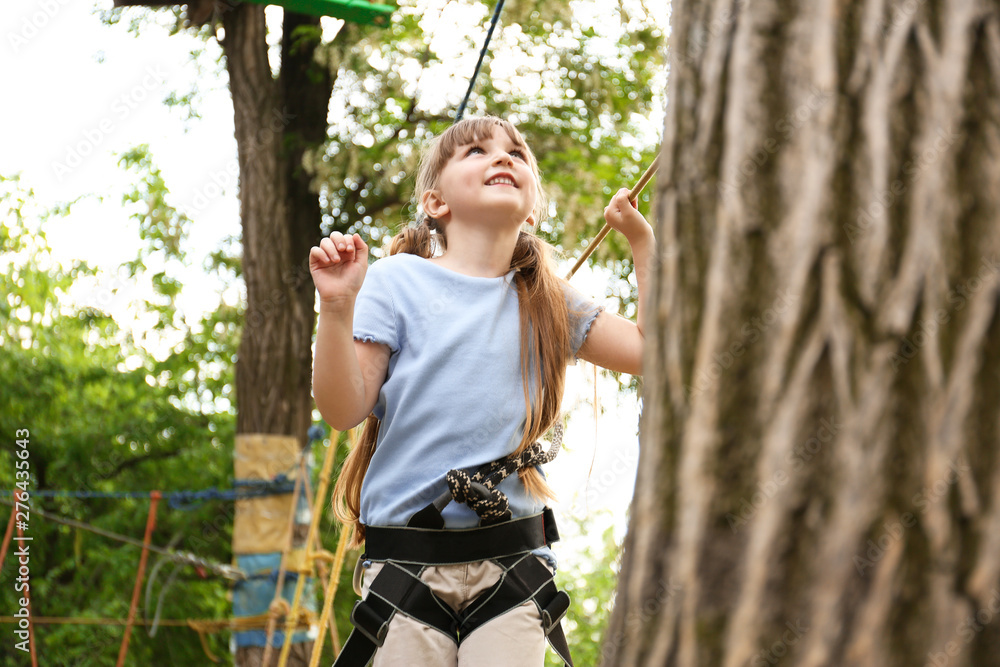 Wall mural Little girl climbing in adventure park. Summer camp