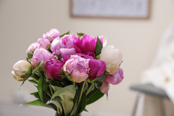 Bouquet of beautiful peonies in room,  space for text