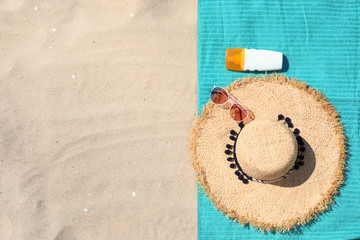 Flat lay composition with beach accessories on sand. Space for text