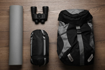 Naklejka premium Flat lay composition with different camping equipment on wooden background