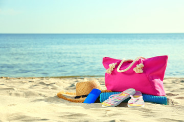 Composition with stylish beach accessories on sand near sea. Space for text