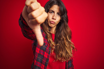 Young beautiful woman wearing casual jacket standing over red isolated background covering eyes with hands smiling cheerful and funny. Blind concept.