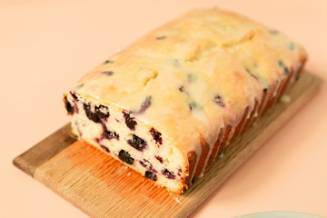Close Up Of Iced Blueberry Lemon Loaf Cake with dripping icing, Pink Background