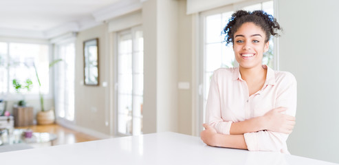 Wide angle of beautiful african american woman with afro hair happy face smiling with crossed arms looking at the camera. Positive person.