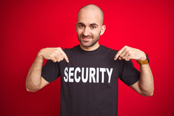 Young safeguard man wearing security uniform over red isolated background looking confident with...