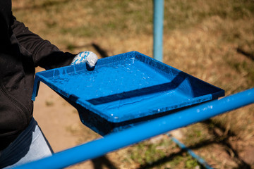 Paint brush. Man paints objects in the yard. Work with color. It's time to upgrade the garden.