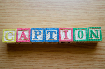 Educational toy cubes with letters organised to display word CAPTION - editing metadata and Search engine optimisation concept