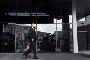 businessman with a bag near the office talking on the phone