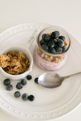 Blueberry Yogurt in Clear Glass with Fresh Blueberries and Honey Granola, Modern Kitchen Background, Spoon