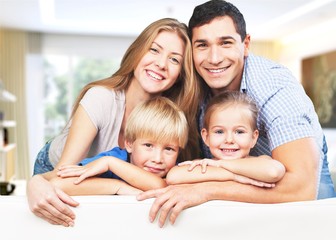 Young  family at home smiling at camera