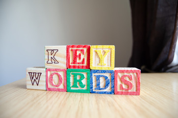Educational toy cubes with letters organised to display word KEYWORDS - editing metadata and Search engine optimisation concept