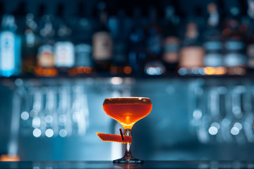 glass of fresh orange cocktail on blue background
