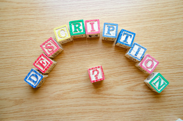 Educational toy cubes with letters organised to display word DESCRIPTION - editing metadata and Search engine optimisation concept