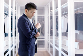 asian business man dress up with walk in clothes wardrobe