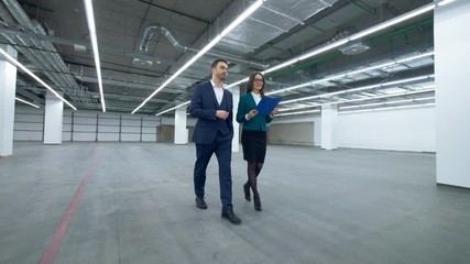 Female real estate agent is guiding a man through an empty property