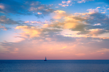 Naklejka na ściany i meble Beautiful sunset over Lake Superior with a sail boat