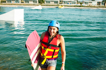 young smiling girl on wake board in water, happy lifestyle people on vacations