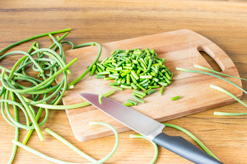 the arrows of garlic chopped with a knife to prepare food stocks for the winter