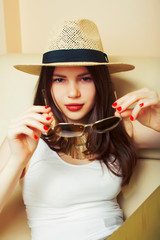 young pretty brunette girl wearing hat and sunglasses waiting alone at home, lifestyle people concept