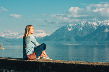 Outdoor portrait of happy young woman relaxing by the lake on a nice sunny day, peacful and...