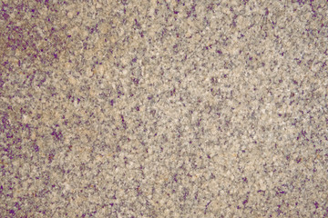 Gray granite slab with streaks and splashes of crimson color.