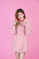 Fashion girl dress up with a hand gesture on a pink background.