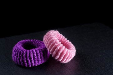 pink and purple hair ties with a stone background