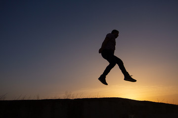 silhouette of man jumping at sunrise