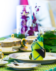 Christmas party dinner table setting with tableware and silverware and glasses set and Candlestick and flower in restaurant.