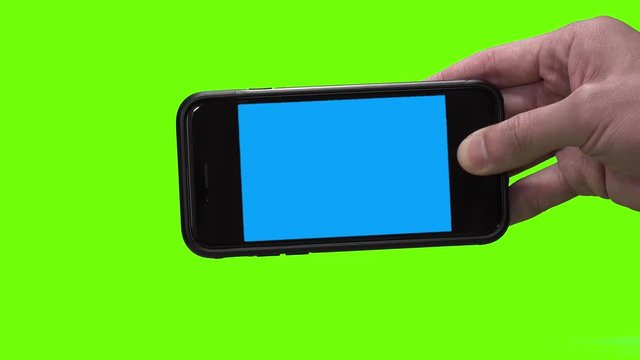 Close up shot of man`s hand holding black smartphone with blue background(chroma key) on screen. One smartphone in horizontal position. Green background (chroma key).