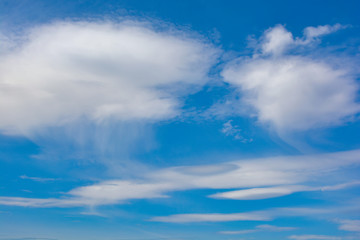 Fluffy white clouds on a blue sky background