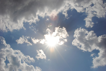 Naklejka na ściany i meble Sun on blue sky with clouds