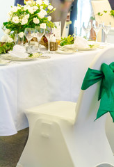 Luxury party dinner table setting with tableware and silverware and glasses set and Candlestick and flower in restaurant.