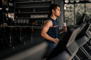 man in sportswear running on treadmill at gym