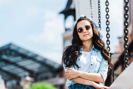 selective focus of beautiful woman in sunglasses smiling while looking at camera