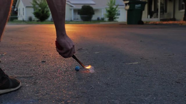 Super Slomo lighting a smoke bomb firework during sunset