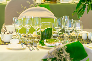 Luxury party dinner table setting with tableware and silverware and glasses set and Candlestick and flower in restaurant.