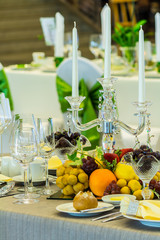 Luxury party dinner table setting with tableware and silverware and glasses set and Candlestick and flower in restaurant.