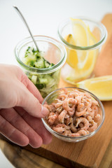 Frau isst Norddeutsche Friesische Nordseekrabben in Glas Schale mit Gurkensalat und Zitronen 