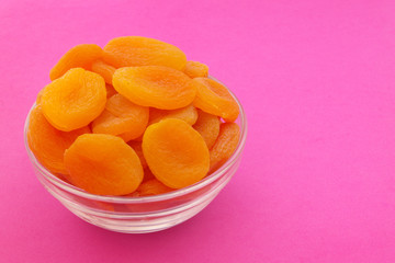 Dried apricots fruits on pink background with room for text