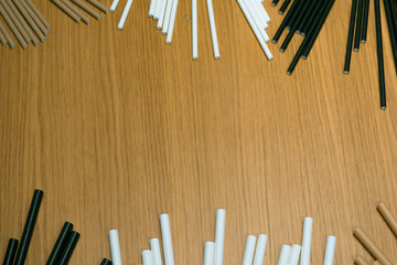 Bundle of paper straws white, brown and black in a wood table display background, great for environmental purpose