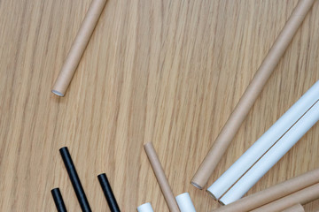 Bundle of paper straws white, brown and black in a wood table display background, great for environmental purpose