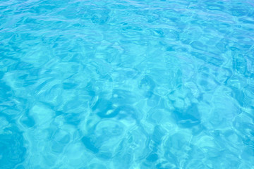 Naklejka na ściany i meble Close-up view of a transparent turquoise sea water that forms a natural texture, Emerald Coast, Sardinia, Italy.